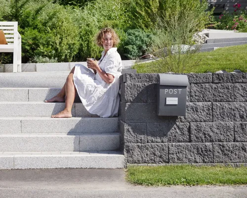 Uterom med Asak Miljøstein, inkludert flettverksmur og modulbasert terrassebelegg, designet for allsidig bruk.