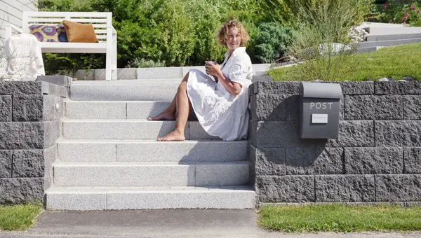 Uterom med Asak Miljøstein, inkludert flettverksmur og modulbasert terrassebelegg, designet for allsidig bruk.