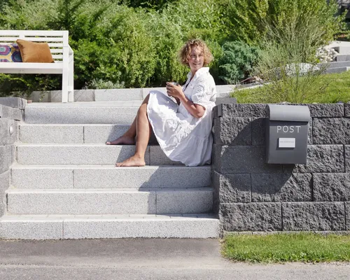 Uterom med Asak Miljøstein, inkludert flettverksmur og modulbasert terrassebelegg, designet for allsidig bruk.